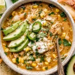 Crock Pot White Chicken Chili served with sliced avocado, jalapeños, sour cream, and crusty bread