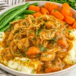 Crockpot Chicken Pot Roast Recipe served over creamy mashed potatoes with carrots and green beans