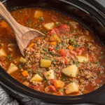 Crockpot Vegetable Beef Soup cooking slowly with ground beef, potatoes, and vegetables inside a slow cooker