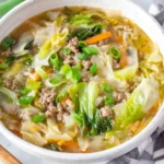 Egg Roll Soup with ground chicken, cabbage, and green onions in a white bowl