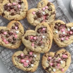 Freshly baked Heart Shaped Chocolate Chip Cookies cooling on a wire rack with pink sprinkles