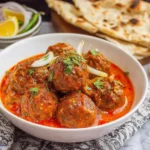 Kofta Curry meatball curry served with naan and fresh cilantro