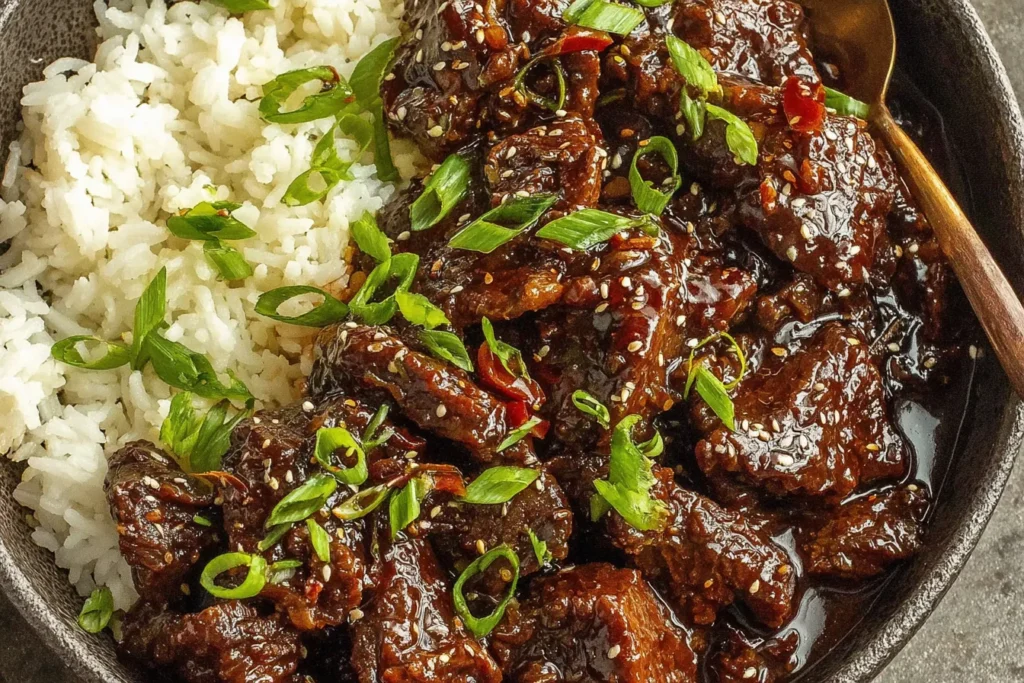 Slow Cooker Korean Beef Recipe served over rice with glossy sauce and green onions