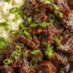 Slow Cooker Korean Beef Recipe served over rice with glossy sauce and green onions