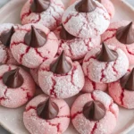 Strawberry Kiss Cookies Recipe served on a plate with powdered sugar and chocolate kisses