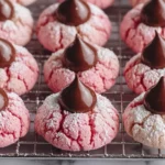 Strawberry Kiss Cookies Recipe cooling on a wire rack with powdered sugar and chocolate kisses