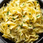 Garlic Butter Noodles in a black bowl, tossed with parmesan, parsley, and cracked black pepper.
