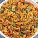 Drunken Noodles (Pad Kee Mao) with chicken, Thai basil, and bell peppers in a glossy savory stir-fry sauce.