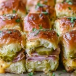 Cuban Inspired Pull-Apart Sliders with ham, Swiss cheese, and dill pickles, brushed with garlic pickle butter and baked until golden and melty.