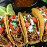 Crock Pot Street Tacos recipe served in mini corn tortillas with shredded beef, pico de gallo, cilantro, queso fresco, and lime wedges.