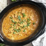Crock pot Sweet Chili Chicken in a slow cooker with creamy shredded chicken, sweet chili sauce, and green onion garnish, served with rice.