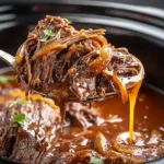 Crock Pot French Onion Pot Roast with tender shredded chuck roast and caramelized onions in rich gravy inside a slow cooker.