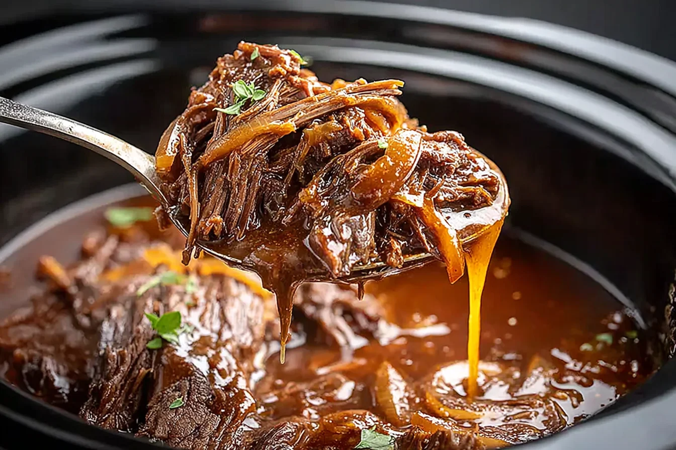 Crock Pot French Onion Pot Roast with tender shredded chuck roast and caramelized onions in rich gravy inside a slow cooker.