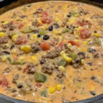 Creamy High-Protein Taco Soup simmering in a skillet with lean ground beef, black beans, corn, tomatoes, and peppers in a rich creamy broth
