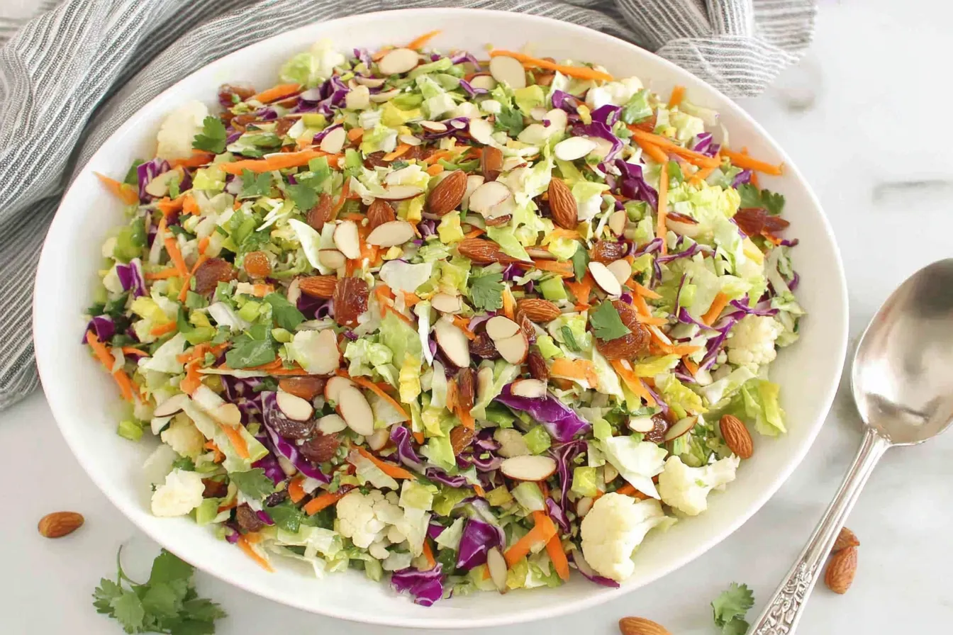 Crunchy Detox Salad with chopped broccoli, cauliflower, cabbage, carrots, almonds and raisins in lemon ginger vinaigrette