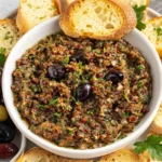 Easy Olive Tapenade Recipe served with toasted baguette slices and mixed olives