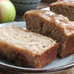 Glazed Apple Cinnamon Oatmeal Bread slices on plate with fresh apple in background