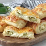 Jalapeno Popper Crescent Rolls sliced open showing creamy cheese filling and jalapeno pieces inside flaky crust