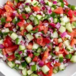 Persian Shirazi Salad with finely chopped cucumbers tomatoes and red onion in a white bowl