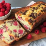 Homemade Raspberry Dark Chocolate Banana Bread with chocolate chips and fresh raspberries on marble background