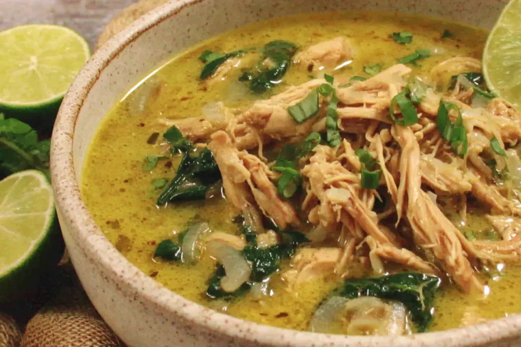Slow-Cooked Thai Ginger Chicken Soup garnished with lime and fresh cilantro