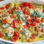 Tomato Basil Artichoke Baked Chicken with roasted cherry tomatoes, artichokes and melted mozzarella in baking dish