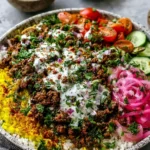 Ground Beef Shawarma Bowls with golden turmeric rice, shawarma-spiced ground beef, cucumbers, cherry tomatoes, pickled red onions, and creamy tahini sauce.