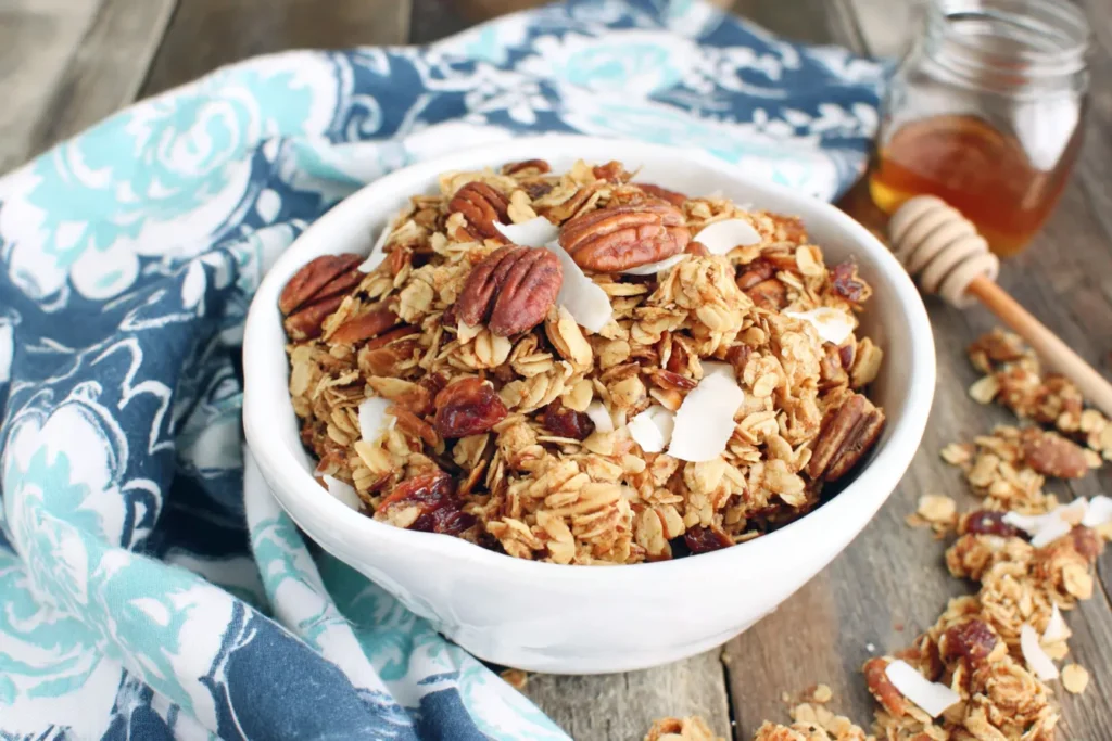 Slow Cooker Granola with toasted oats, pecans, coconut flakes and honey served in a bowl