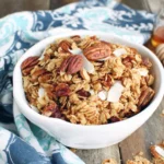 Slow Cooker Granola with toasted oats, pecans, coconut flakes and honey served in a bowl
