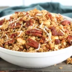 Slow Cooker Granola served in a bowl with toasted oats, pecans, coconut flakes, and dried fruit