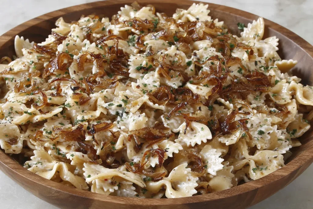 French Onion Pasta Salad with creamy dressing and caramelized onions in a wooden bowl