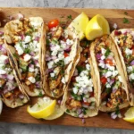 Grilled Mediterranean Chicken Tacos with feta, fresh veggies, and tzatziki on warm pita