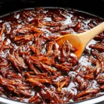 Slow Cooker BBQ Beef Brisket inside the crockpot with shredded beef and smoky barbecue sauce