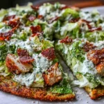 Chicken Crust Caesar Salad Pizza slices on parchment, topped with romaine, creamy Caesar dressing, Parmesan, and crispy chicken bits.