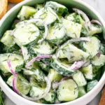 Creamy Cucumber Dill Salad with sliced cucumbers, red onion, and fresh dill in a bowl.