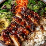 Sticky Chicken Poke Bowls with glazed sticky chicken over rice, broccoli, avocado, and sesame seeds in a healthy weeknight bowl.