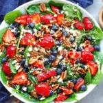 Strawberry Spinach Salad topped with strawberries, blueberries, feta, toasted pecans, and balsamic glaze, with extra berries on the side
