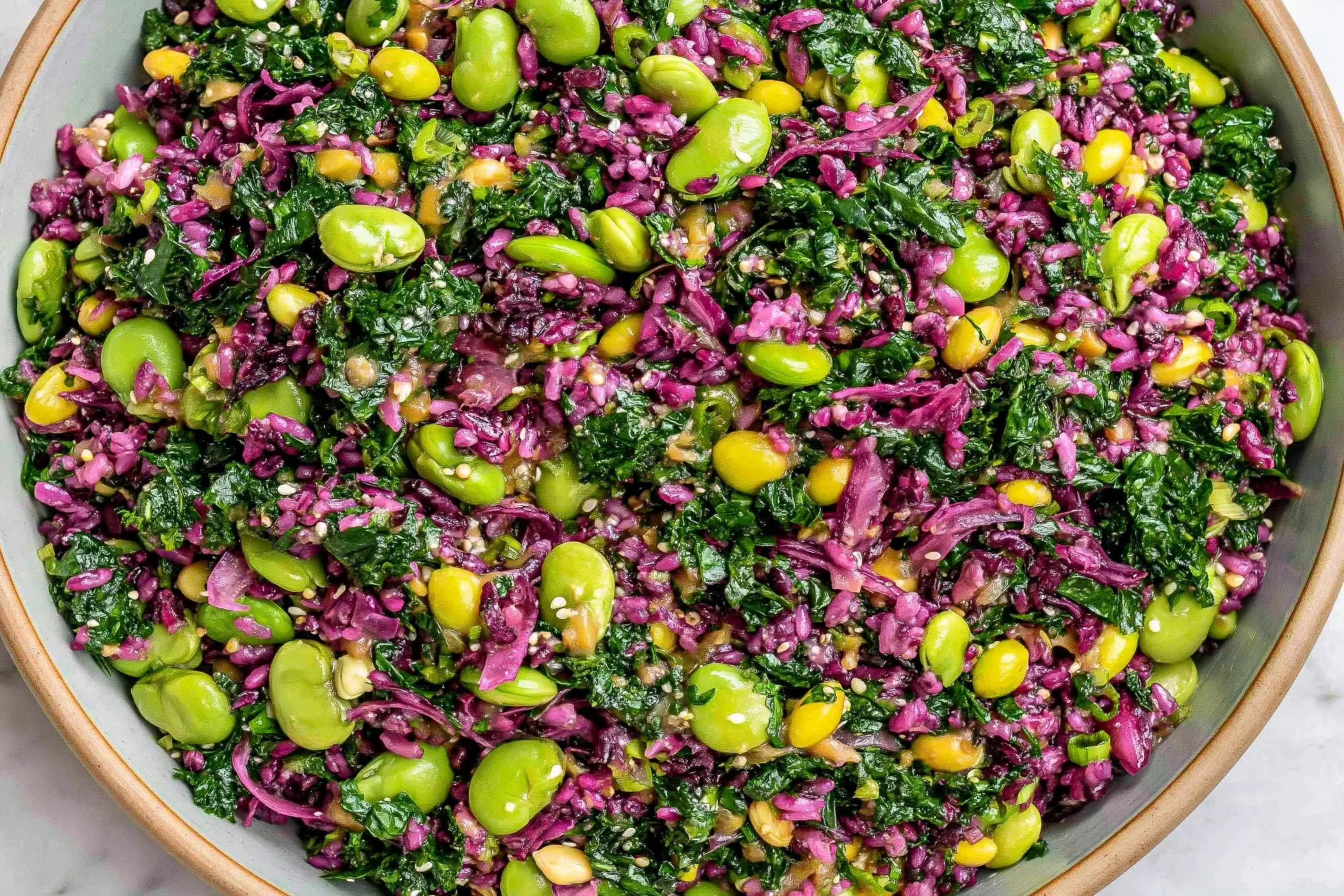 Longevity Miso Bowl with kale, red cabbage, edamame, sesame seeds, and fresh herbs in a zesty miso-ginger dressing