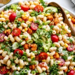 Buffalo Chickpea Pasta Salad in a large bowl with creamy ranch pasta, crispy buffalo chickpeas, cherry tomatoes, corn, avocado, cilantro, and green onions.