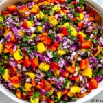 Black Bean Mango Salad with black beans, diced mango, red onion, bell pepper, cilantro, and lime in a white serving bowl