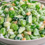 Cucumber Edamame Salad with creamy miso dressing, chopped cucumbers, edamame, cashews, sesame seeds, and green onions in a bowl