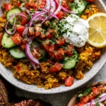 Golden Ground Turkey and Rice Skillet topped with cucumber tomato salad, red onion, lemony yogurt, fresh herbs, and lemon slice.