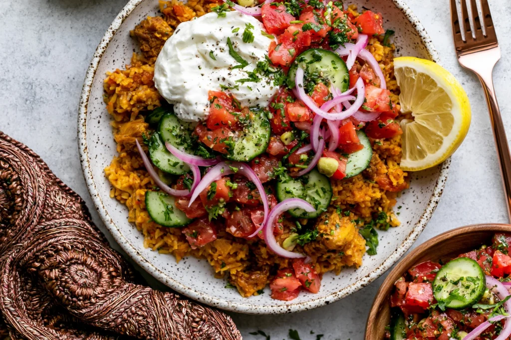 Golden Ground Turkey and Rice Skillet with lemony yogurt, cucumber tomato salad, red onion, fresh herbs, golden rice, and lemon wedge.