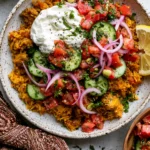 Golden Ground Turkey and Rice Skillet with lemony yogurt, cucumber tomato salad, red onion, fresh herbs, golden rice, and lemon wedge.