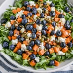 Honey Sweet Potato Summer Salad with roasted sweet potatoes, blueberries, arugula, goat cheese, pepitas, and pine nuts with honey lemon vinaigrette.
