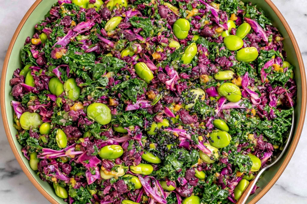 Longevity Miso Bowl salad with kale, red cabbage, edamame, black sesame seeds, and miso-ginger dressing in a green bowl