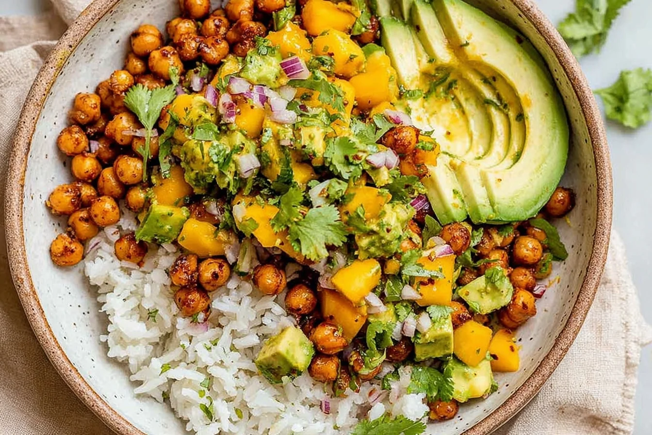 Protein-packed bowl of Mango Chickpea Salad with crispy chickpeas, fluffy rice, creamy avocado slices, and fresh cilantro-lime mango salsa.
