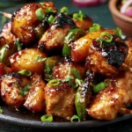 Jalapeno Peach Chicken Skewers with glazed chicken, juicy peaches, and green jalapeno pieces served on a dark plate
