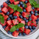 Watermelon Blueberry Salad with fresh mint in a white bowl, a refreshing summer fruit salad with honey lime dressing